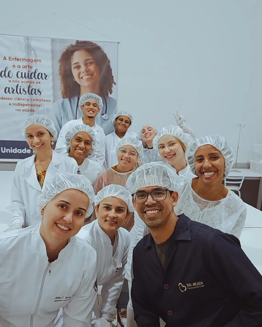 Turma da Unopar Ituiutaba sorrindo, de jaleco e touca, no laboratório da unidade